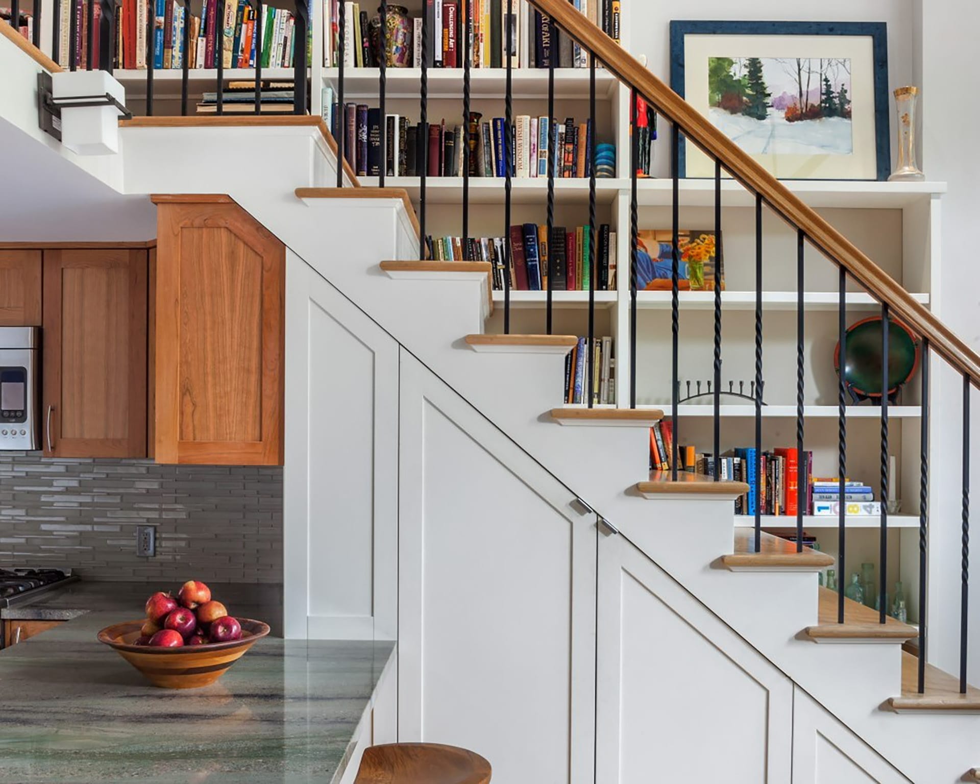 Staircase lined with built-in bookshelves and open metal railings.